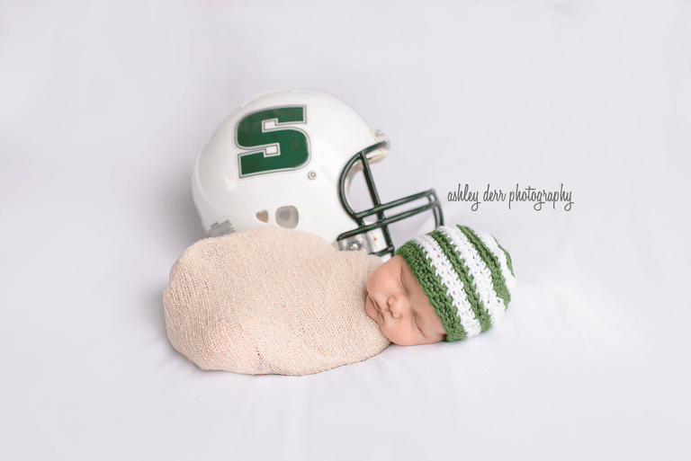 newborn baby with football pose